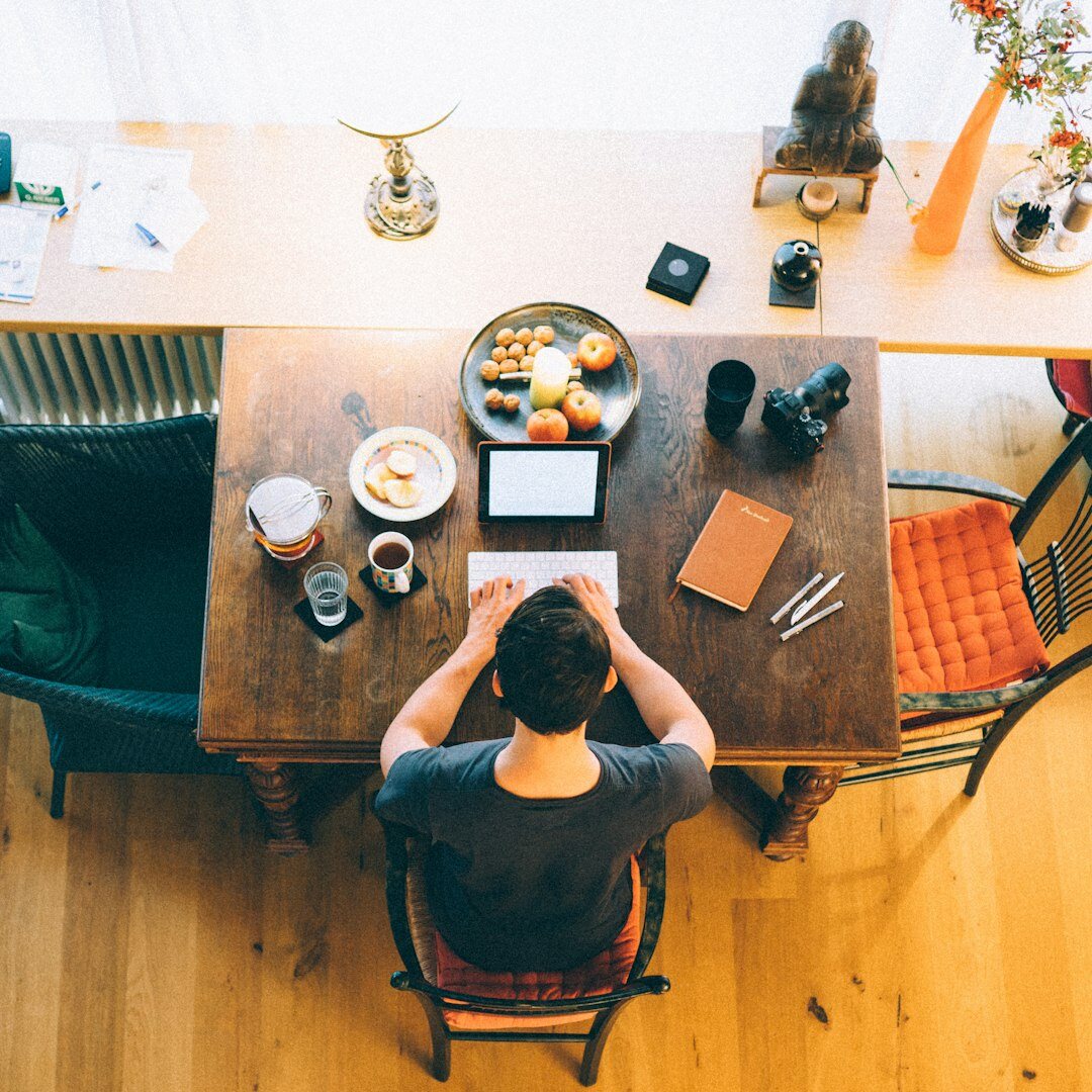 Chilean journalist writing at a desk with a laptop and notebooks